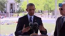 President Obama stands behind a lectern delivering a speech.