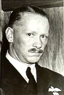 Informal head-and-shoulders portrait of mustachioed man in dark uniform
