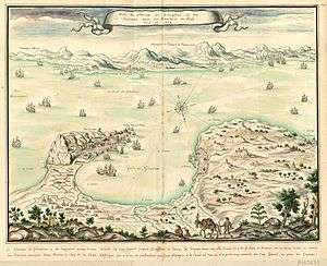 Coloured engraving of the Bay of Gibraltar as if seen from the top of a mountain to the north. Gibraltar is shown on the left, Algeciras on the right and the African coast in the background. The Spanish lines and camp are visible in the left foreground. Numerous ships are portrayed, some of them opening fire.