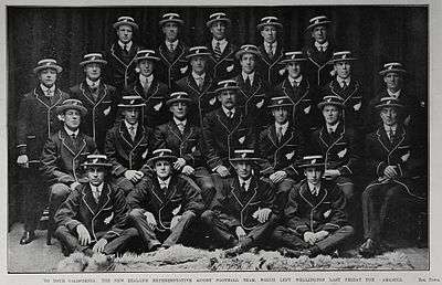 A team of men wearing blazers and hats posing for a formal photo.