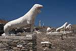 A row of white lion sculptures on pedestals.