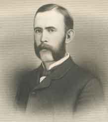 A young man, facing left, with thinning black hair, sideburns, and a mustache. He is wearing a white shirt, black tie, and black jacket buttoned up to the neck