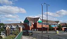 A 1980s medium-sized supermarket building, viewed from across the Great North Road