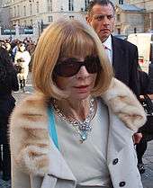 Anna Wintour wearing sunglasses as she walks along a street in Germany