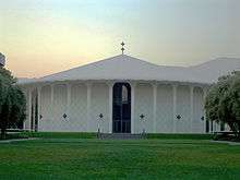 Photo of a  circular building surrounded by grass.