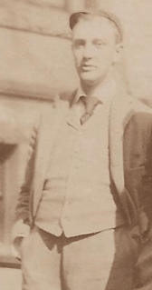 A grainy image of a man in a hat and a jacket posing for a picture