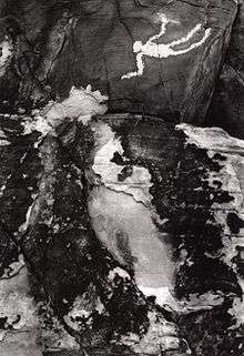 A black-and-white photograph of a Native American petroglyph.