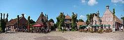 Brick houses and trees around an empty market square