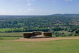 Photograph taken from behind stone viewing platform showing landscape beneath the hill.