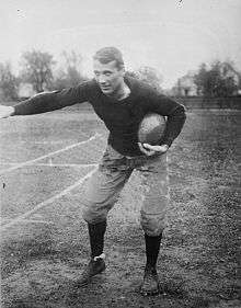 Man holding football facing left