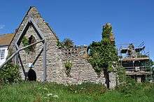 Stone wall with window of ruined building.