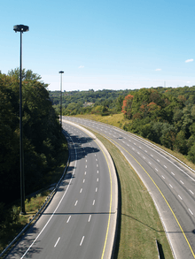 An empty six-lane highway in a forested valley