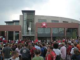 New building with students gathered for dedication ceremony