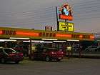 shot under the canopy of a lit-up car-hop restaurant at twilight