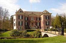 Red brick front of the building with a stone bridge leading to the entrance