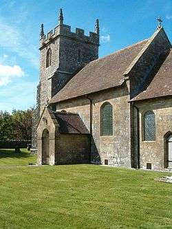 Brown stone building with porch and tiled roof. Square tower to left hand end.