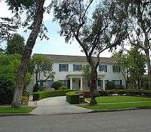 A white house with blue shutters is pictured