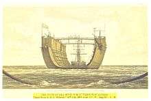 A floating dry dock, a large, U-shaped vessel, on the high seas, being towed by a sailing ship.