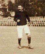 B&W photo of middleaged man standing on a pitch with a football