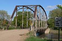 Bridge on gravel road, consisting of one steel through truss