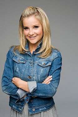 A young woman wearing a blue denim jacket and grey skirt.