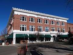 Photograph of a three-story building on a city street corner