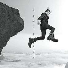 A man wearing climbing boots jumps off of an iron mountain.