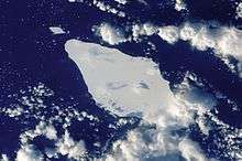 Overhead photo of iceberg with surrounding clouds