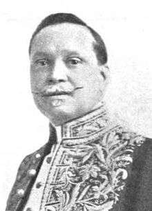 Man with moustache in ornate, high-collared shirt