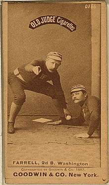 A picture depicting a baseball player who is holding a ball that tagging out another baseball player who attempting to reach base