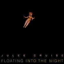 A porcelain doll floating against a black background. Pink block text with wide kerning below reads "Julee Cruise"; grey block text placed below reads "Floating", followed by gold block text reading "into the Night".