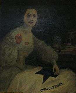 Portrait of an attractive young woman in mid-19th century dress sewing a flag that says "Liberty or Death"