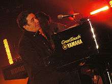 Jools Holland playing a piano on stage