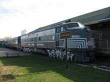 Color photograph of a New York Central diesel-engine train sitting at a station