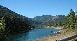 A large river flowing through forested hills