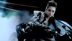 Still from the music video "Ecstasy", showing Koda on a bike; this look was adapted on the CD version of 3 Splash.