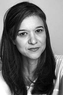 Headshot of Boushnak looking into camera. Long, dark hair. Black and white photo.