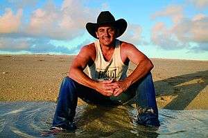 Man in black hat sitting on ground