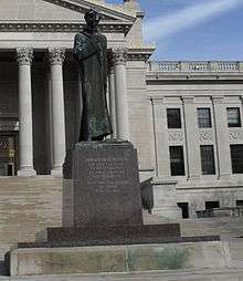 A statue of Abraham Lincoln in a robe, looking pensive