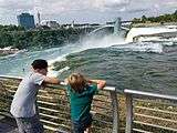 Boys overlooking American Falls with view of buildings on Canadian side