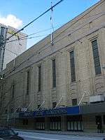 An exterior view of a building. The building has a sign that says "Maple Leaf Gardens" on the front.