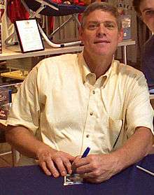 Murphy seated at a table looking to the camera