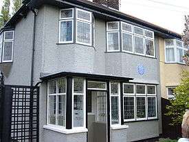 A grey two-storey building, with numerous windows visible on both levels