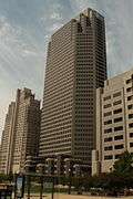 A tall, thin building with small windows is nestled between two other buildings.