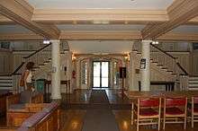 A wood-floored room with a doorway and staircases