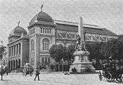 Old building with two domes and a statue in front