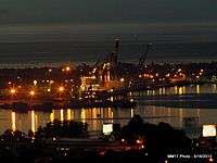 Seaport at night, with lights reflecting on the water