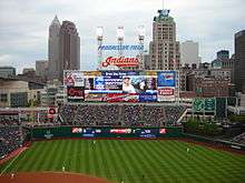 A baseball scoreboard with a skyline in the background