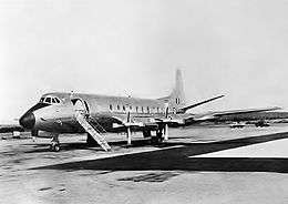 Four-engined turboprop passenger plane parked on airstrip