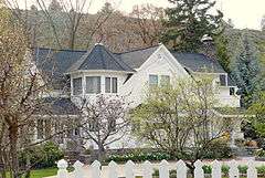 Photograph of the Richardson–Ulrich House, a white, two-story house partially obscured by trees